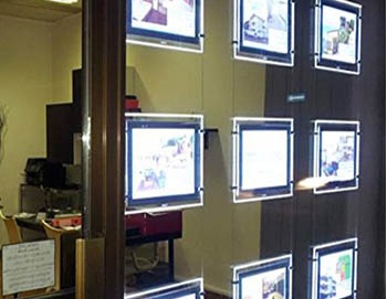 LED window display panel showing real estate listings in storefront