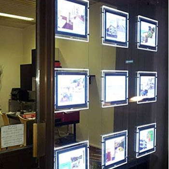 LED window display panel showing real estate listings in storefront
